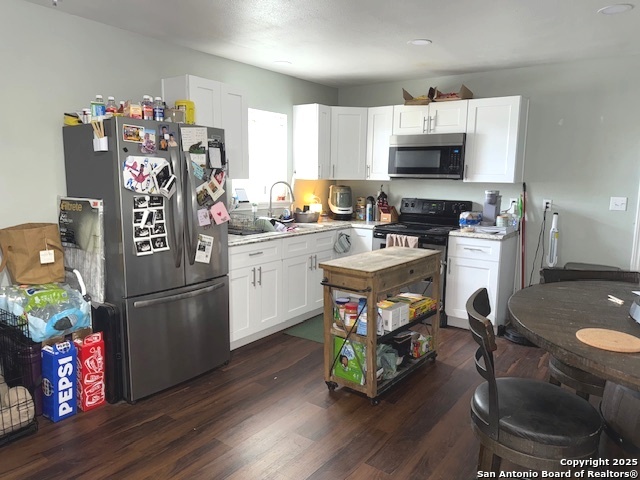 433 West Adams Street Pleasanton, TX 78064 - Photo 4 of 13 a kitchen with stainless steel appliances a stove a sink cabinets and a refrigerator