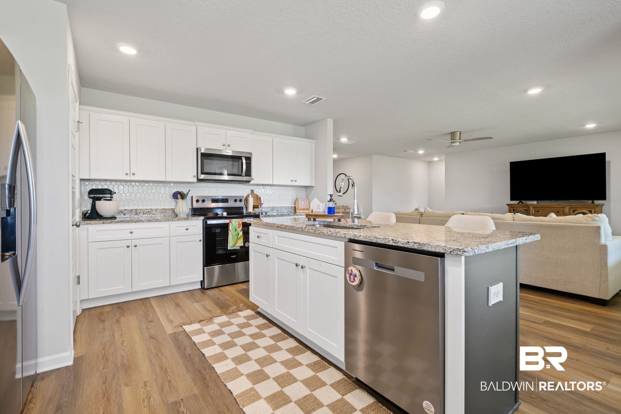 8021 Valor Rdg Way North Mobile, AL 36619 - Photo 27 of 34 Modern kitchen featuring white shaker cabinetry, stainless steel appliances, speckled stone countertops, and a full tile backsplash