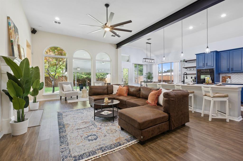 a living room with furniture kitchen and a large window