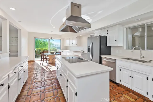 a large white kitchen with a large window appliances and cabinets