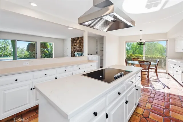 a kitchen with granite countertop a sink a stove and white cabinets with wooden floor