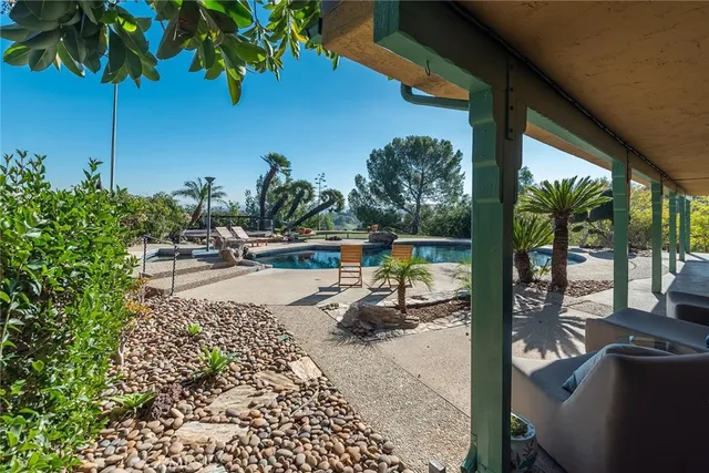 a swimming pool with outdoor seating and a garden