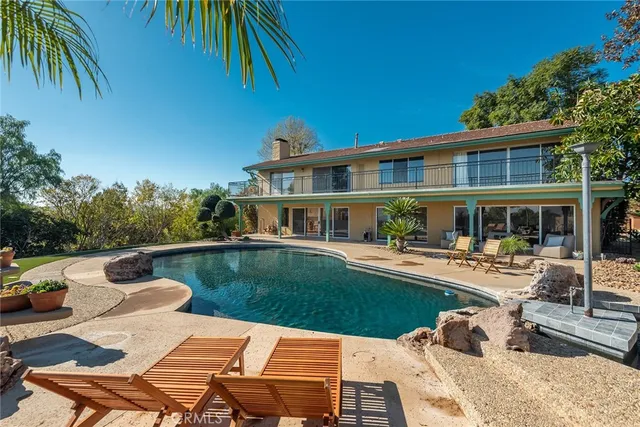 a front view of a house with swimming pool having outdoor seating