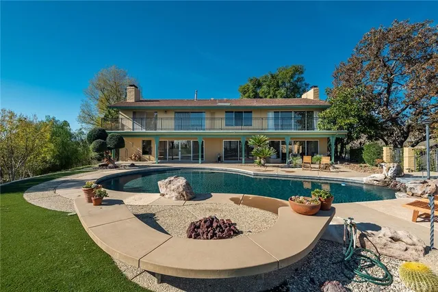 a front view of a house with swimming pool having outdoor seating