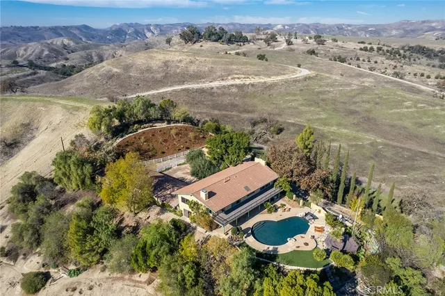 an aerial view of residential houses with outdoor space and ocean view