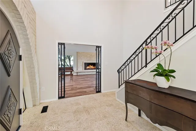 a hallway with wooden floor potted plants and stairs
