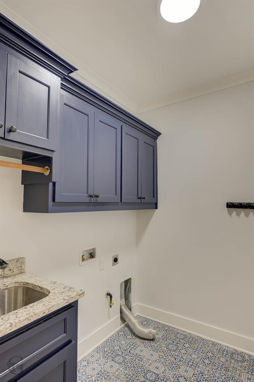 605 Meridian Way Benton, LA 71006 - Photo 12 of 29 Utility space featuring patterned tile flooring, blue shaker-style cabinetry, granite-finish countertop with an undermount stainless steel sink, and crown molding