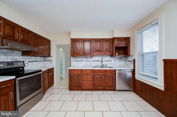 a large kitchen with stainless steel appliances granite countertop a stove sink and cabinets