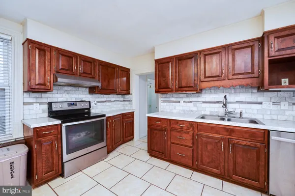a kitchen with stainless steel appliances granite countertop wooden cabinets a stove top oven a sink and dishwasher