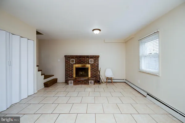 a view of an empty room with a fireplace and a window