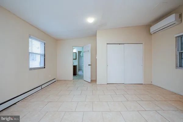 an empty room with windows and closet