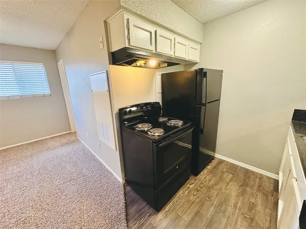 a kitchen with stainless steel appliances granite countertop a refrigerator and a stove top oven