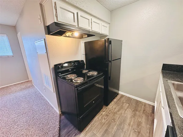 a kitchen with stainless steel appliances granite countertop a refrigerator and a stove