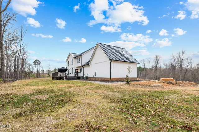 a front view of a house with a garden and trees