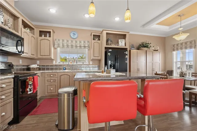 a kitchen with stainless steel appliances granite countertop a stove a sink dishwasher and cabinets with wooden floor