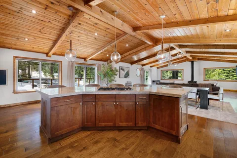 a open kitchen with wooden floors and wooden cabinets