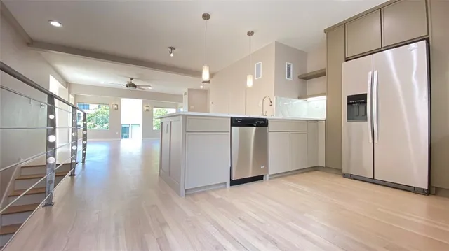 a kitchen with stainless steel appliances a refrigerator and wooden floor