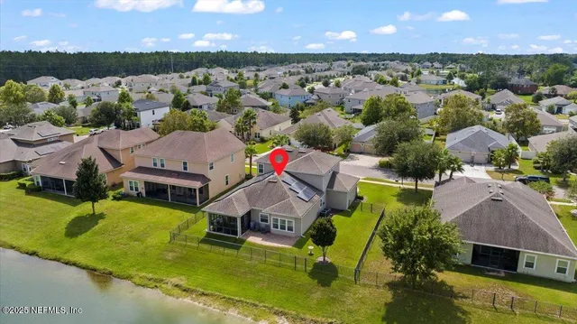 an aerial view of residential houses with outdoor space and lake view