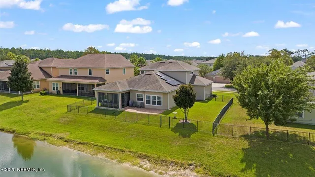 an aerial view of a house with a garden and lake view