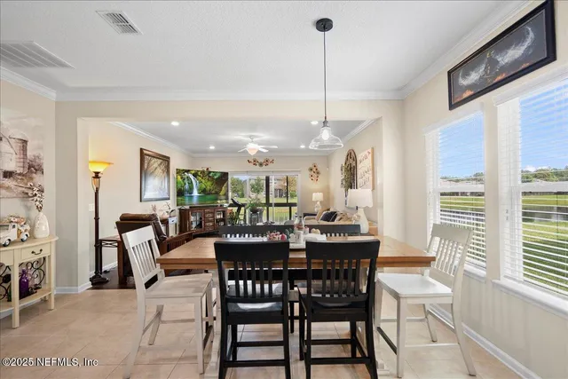 a view of a dining room and livingroom with furniture wooden floor a chandelier