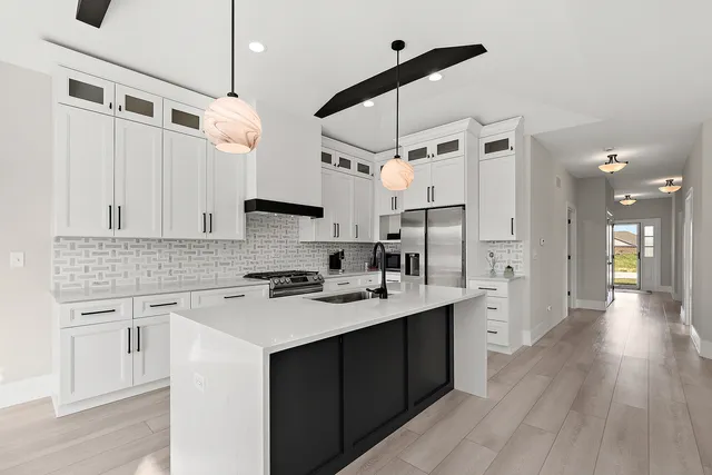 a kitchen with a sink a counter space appliances and cabinets