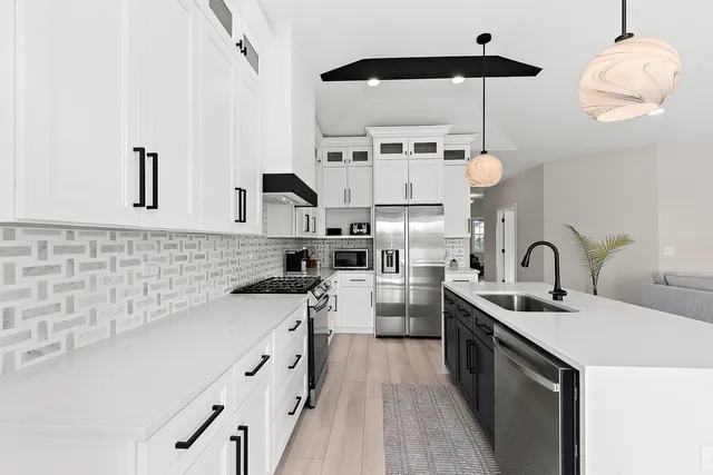 a kitchen with stainless steel appliances a sink a stove and a wooden floors