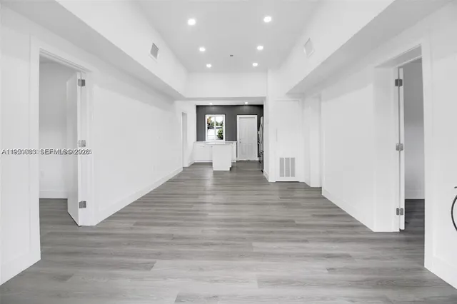 a view of empty room with wooden floor