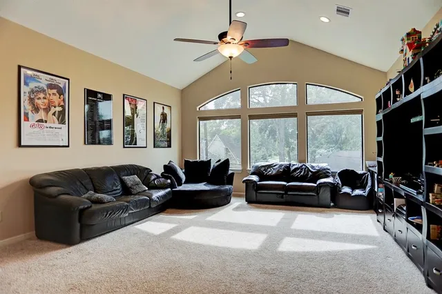 a living room with furniture a flat screen tv and a large window