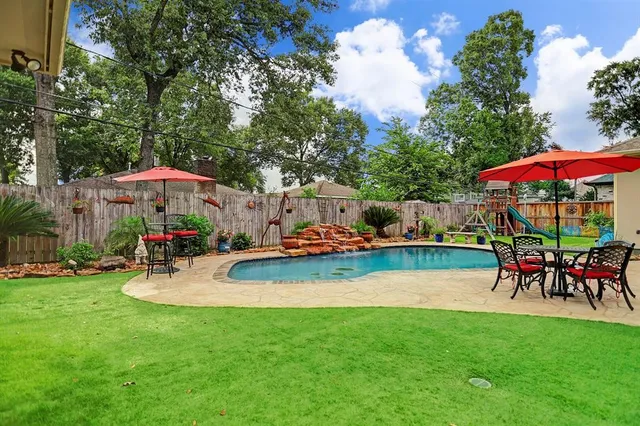 a view of a swimming pool with lawn chairs under an umbrella