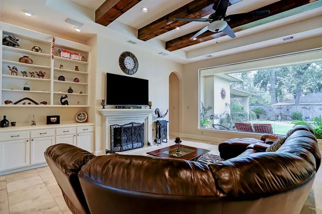 a living room with furniture a fireplace and a flat screen tv