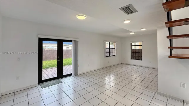 an empty room with windows and ceiling fan