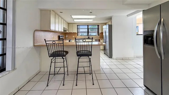 a view of kitchen with furniture and refrigerator