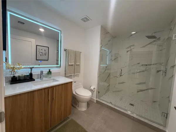 a bathroom with a sink a toilet and shower