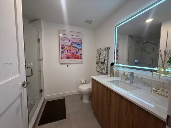 a bathroom with a double vanity sink toilet and a mirror