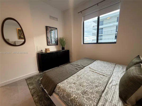 a bed sitting in a bedroom next to a window