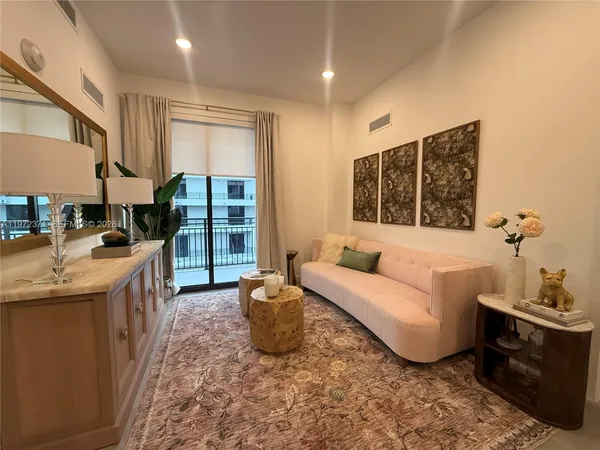 a living room with furniture a large window and a fireplace