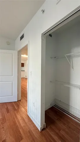 a view of room with cabinets and wooden floor