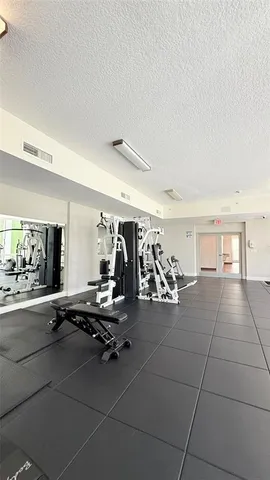 a view of living room filled with furniture and gym equipment