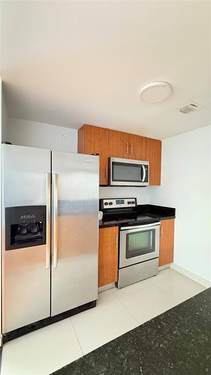 601 Northeast 23rd Street, Unit 902 Miami, FL 33137 - Photo 7 of 49 a kitchen with stainless steel appliances a stove a microwave and a refrigerator