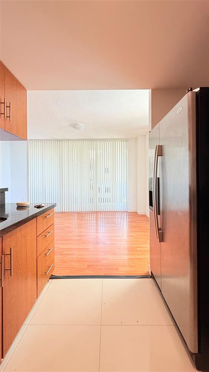 601 Northeast 23rd Street, Unit 902 Miami, FL 33137 - Photo 9 of 49 a view of a kitchen with kitchen island a sink wooden floor and a refrigerator