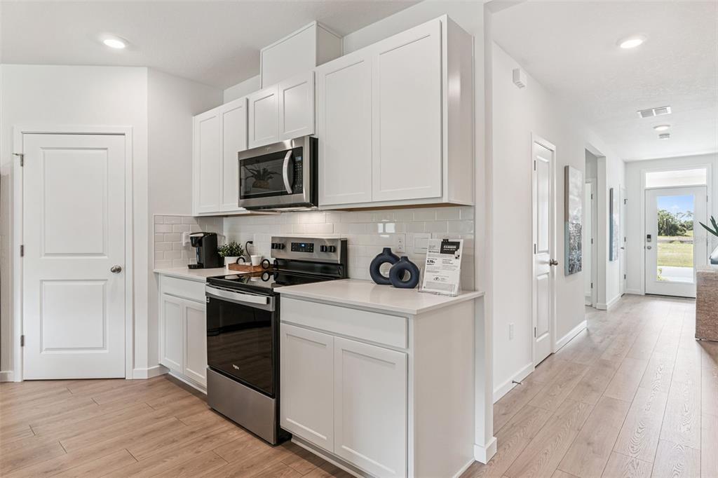 2827 House Finch Road St. Cloud, FL 34773 - Photo 11 of 70 a kitchen with stainless steel appliances granite countertop a stove and a refrigerator
