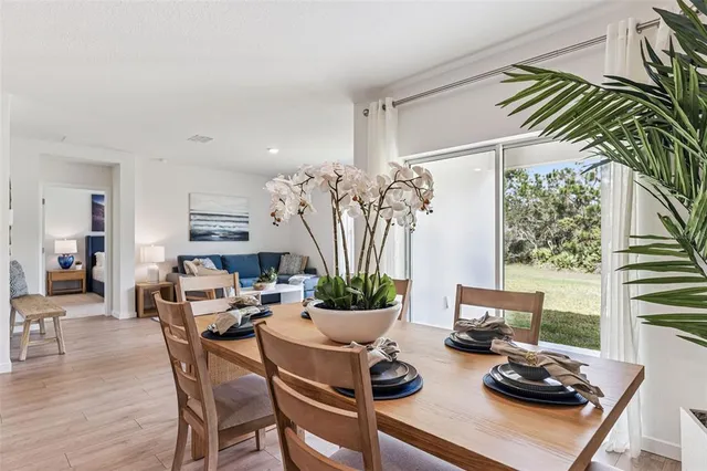 a kitchen with sink refrigerator dining table and chairs