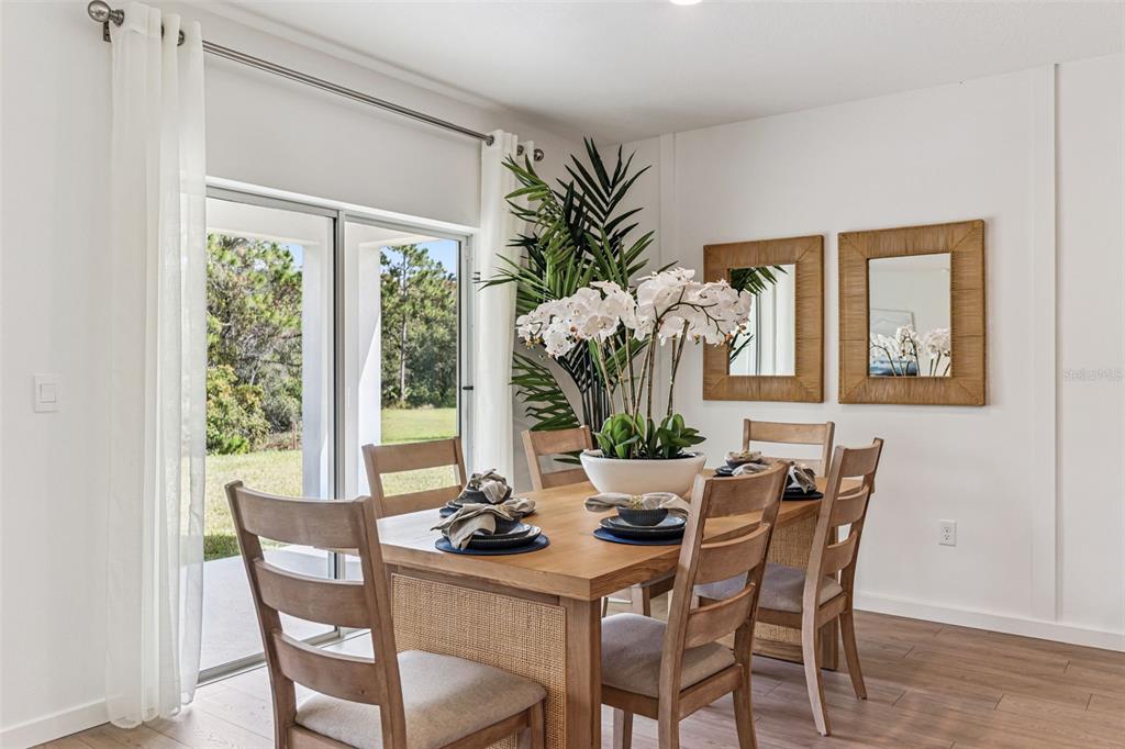 2827 House Finch Road St. Cloud, FL 34773 - Photo 9 of 70 a dining room with furniture potted plants and wooden floor