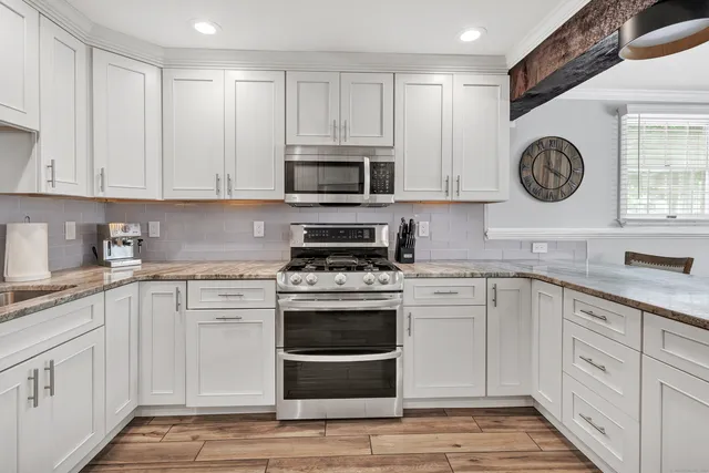 a kitchen with cabinets stainless steel appliances a sink and a stove