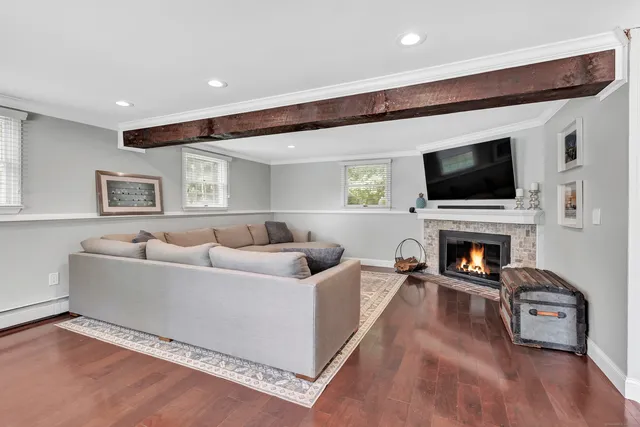 a living room with furniture a fireplace and a flat screen tv