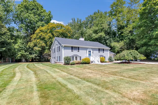 a view of a house with backyard and tree