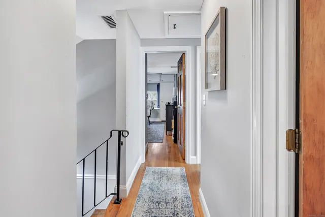 a view of a hallway with a white walls and a door