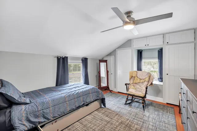 a bedroom with a bed a chair and next to a window