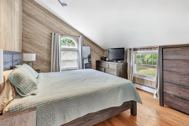a bedroom with a bed and wooden floor