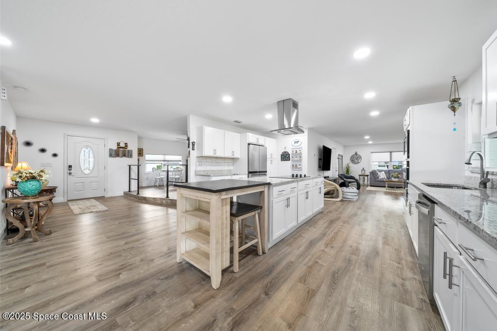 1253 St Andrews Drive Rockledge, FL 32955 - Photo 15 of 33 a large kitchen with stainless steel appliances granite countertop a lot of counter space and wooden floor